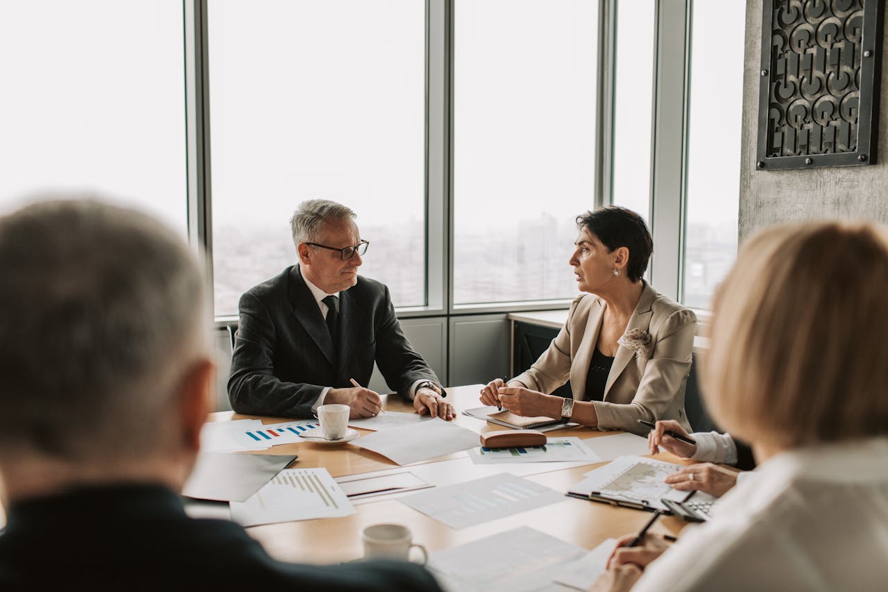 about-03 Business professionals engaged in a strategic meeting in a modern office setting with natural light.